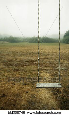 A empty children's' swing in a field View Large Photo Image Stock Photograph - A empty children's' swing in a field. Fotosearch