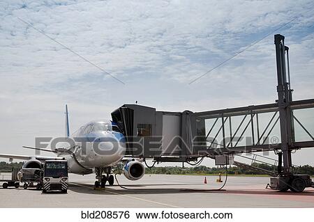 Stock Photograph - A passenger aircraft at the departure gate walkway. Fotosearch