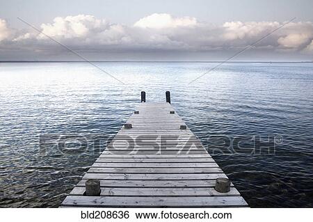 Stock Photograph - A wooden jetty reaching out into the waters of Lake Taupo. Fotosearch
