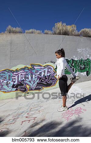 Stock Image - Active Cuban woman stretching before exercise. Fotosearch