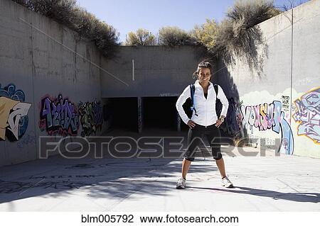 Stock Image - Active Cuban woman with backpack in aqueduct. Fotosearch
