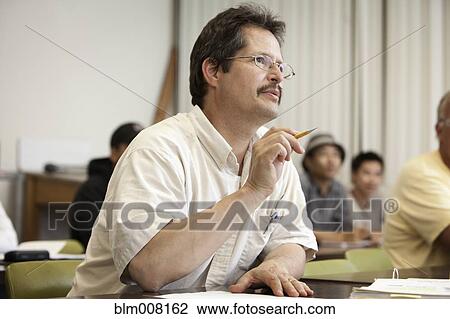 Stock Image - Adult student talking in classroom. Fotosearch