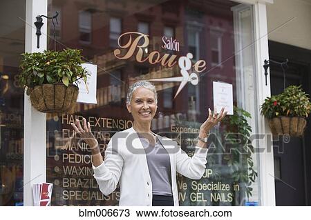Stock Image - African American beauty salon owner standing outdoors. Fotosearch