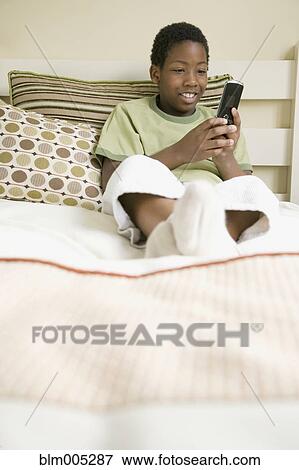 African American boy text messaging on cell phone View Large Photo Image Stock Photo - African American boy text messaging on cell phone. Fotosearch