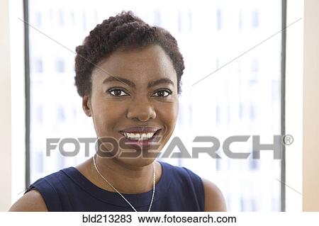 Stock Image - African American businesswoman smiling in office. Fotosearch