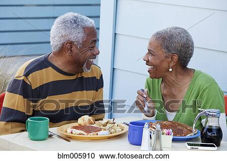 Stock Image - African American couple eating breakfast in cafe. Fotosearch
