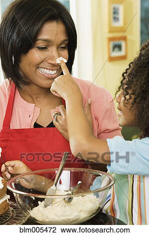 African American daughter putting icing on mother's nose View Large Photo Image Stock Image - African American daughter putting icing on mother's nose. Fotosearch