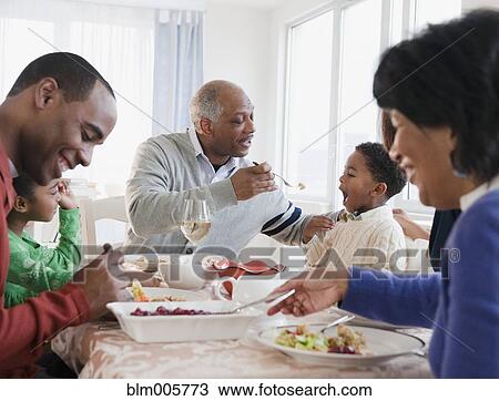 Stock Image - African American family enjoying Thanksgiving dinner. Fotosearch