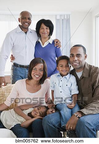 Stock Image - African American family sitting in living room. Fotosearch