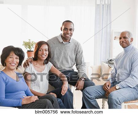 Stock Photograph - African American family sitting in living room. Fotosearch