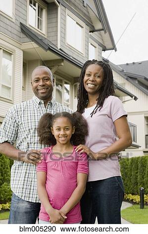 Stock Image - African American family standing outside house. Fotosearch