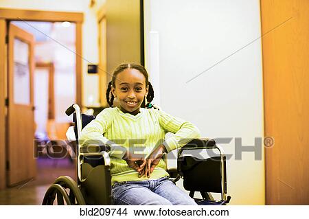 Picture - African American girl sitting in wheelchair. Fotosearch