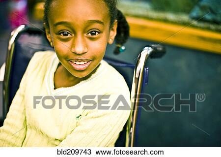 Stock Image - African American girl sitting in wheelchair. Fotosearch