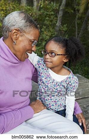 Stock Image - African American grandmother and granddaughter hugging. Fotosearch