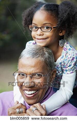 Stock Photo - African American grandmother and granddaughter hugging. Fotosearch