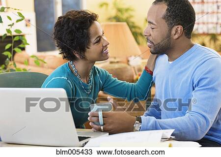 Stock Image - African American husband and wife sitting at computer. Fotosearch