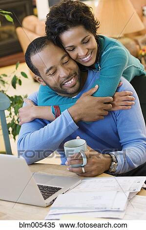 Stock Photography - African American husband hugging wife. Fotosearch