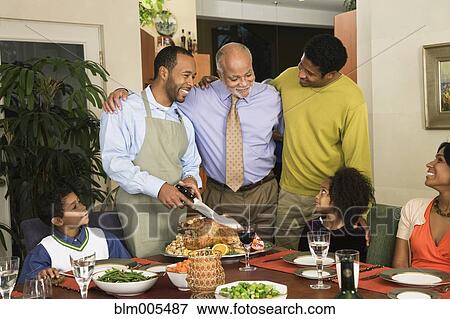 Stock Photo - African American man carving Thanksgiving turkey. Fotosearch
