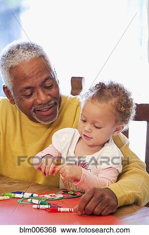 Stock Photo - African American man drawing with granddaughter. Fotosearch