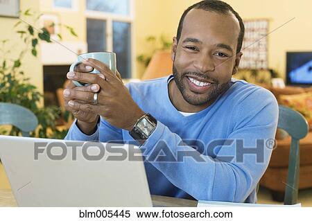 Stock Photography - African American man drinking coffee. Fotosearch