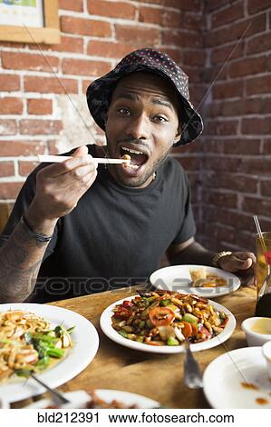 African American man eating at restaurant View Large Photo Image Stock Image - African American man eating at restaurant. Fotosearch