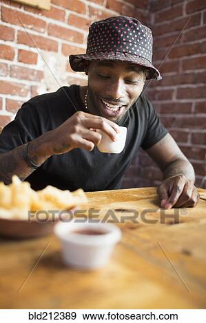 African American man having drink in restaurant View Large Photo Image Stock Photo - African American man having drink in restaurant. Fotosearch