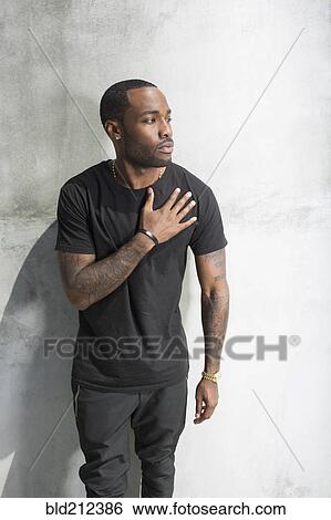 Stock Photograph - African American man holding his chest. Fotosearch