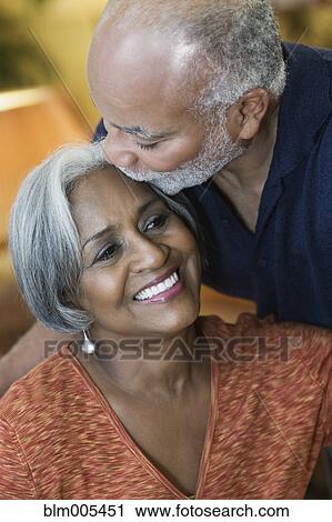 Stock Image - African American man kissing wife's forehead. Fotosearch