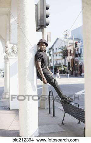 Picture - African American man standing on city street. Fotosearch