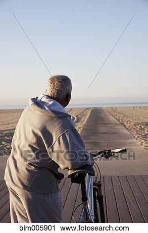 African American man standing with bicycle on beach View Large Photo Image Stock Image - African American man standing with bicycle on beach. Fotosearch