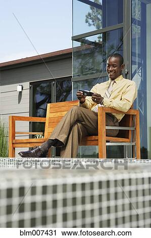 African American man text messaging on cell phone by swimming pool View Large Photo Image Stock Image - African American man text messaging on cell phone by swimming pool. Fotosearch