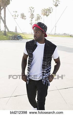 Stock Photo - African American man walking on city street. Fotosearch