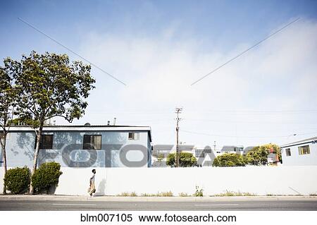 Stock Photography - African American man walking on sidewalk. Fotosearch