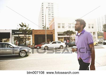 African American man with coffee cup walking on sidewalk View Large Photo Image Stock Photo - African American man with coffee cup walking on sidewalk. Fotosearch