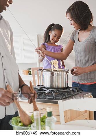 Stock Photo - African American mother and daughter preparing dinner. Fotosearch