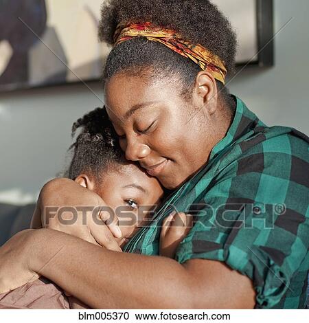 Stock Image - African American mother comforting daughter. Fotosearch