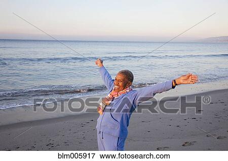 Stock Photo - African American woman excited on beach. Fotosearch