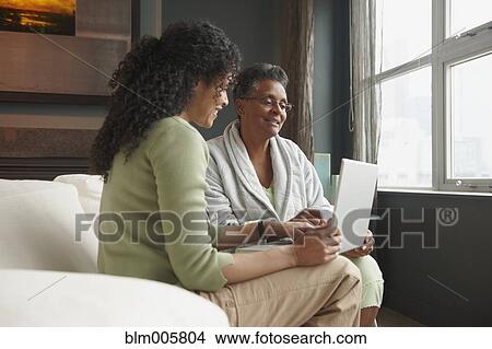 Picture - African American woman helping mother with laptop. Fotosearch