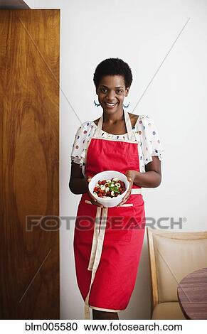 Stock Image - African American woman holding a bowl of salad. Fotosearch