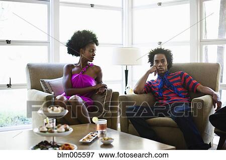 Stock Photo - African American woman sitting at cocktail party with boyfriend. Fotosearch