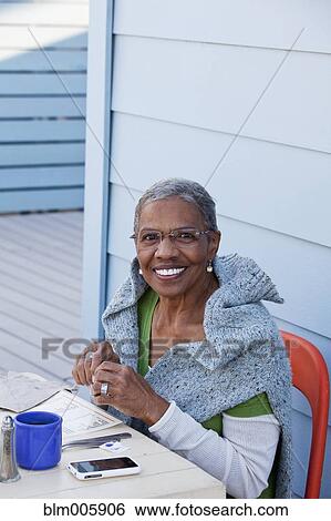 Stock Photograph - African American woman sitting in cafe. Fotosearch