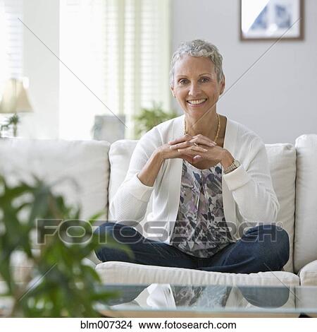 Picture - African American woman sitting on sofa. Fotosearch