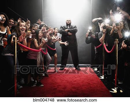 Stock Photo - African bouncer protecting entrance at the end of red carpet. Fotosearch