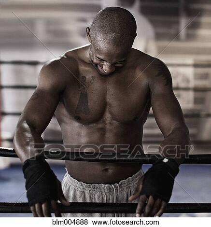 Stock Photo - African boxer in boxing ring laughing. Fotosearch