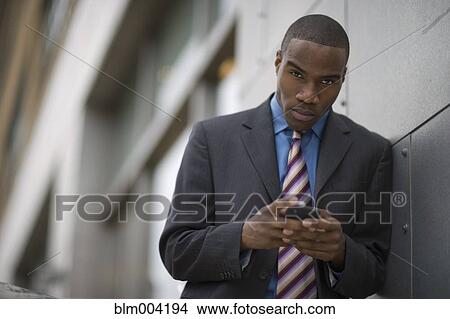 African businessman holding cell phone View Large Photo Image Picture - African businessman holding cell phone. Fotosearch