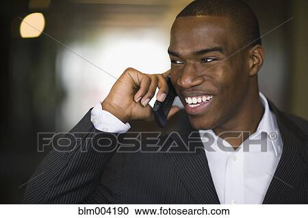 Stock Image - African businessman talking on cell phone. Fotosearch