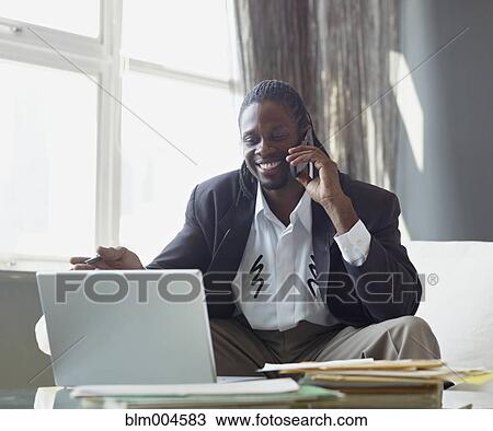 Stock Image - African businessman talking on cell phone. Fotosearch