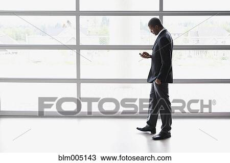 African businessman text messaging on cell phone View Large Photo Image Stock Image - African businessman text messaging on cell phone. Fotosearch