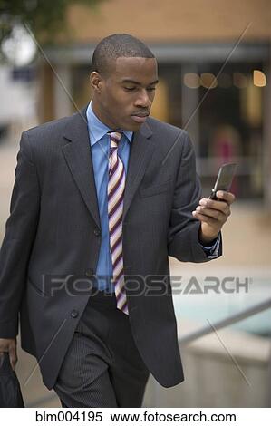 African businessman using cell phone View Large Photo Image Stock Photography - African businessman using cell phone. Fotosearch