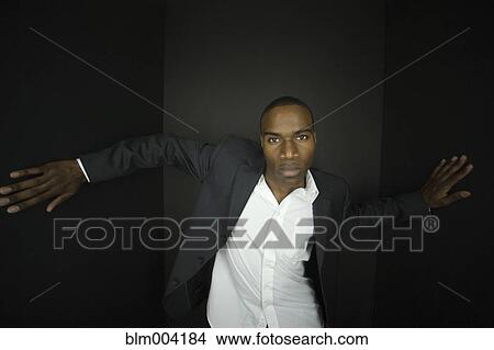 Picture - African businessman with arms outstretched. Fotosearch